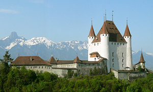 Schloss Thun mit Bergen im Hintergrund