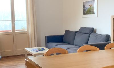 Gemütliche Sofaecke mit Stühlen und Tisch und Spielschrank