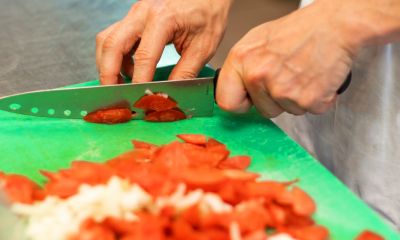 Mitarbeiter, der Tomaten schneidet