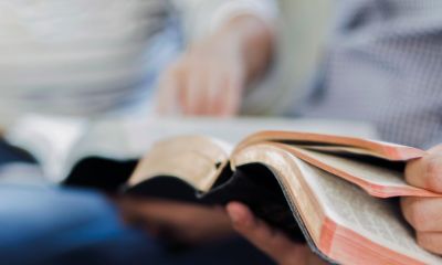 Zwei Menschen mit aufgeschlagener Bibel 