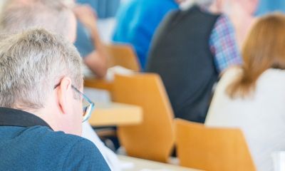 Teilnehmer in der Aula beim Zuhören