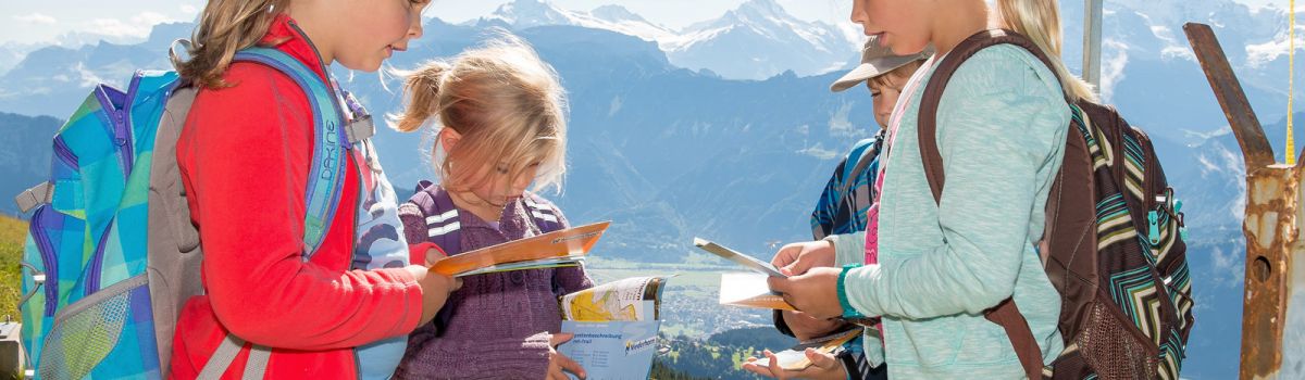 Kinder beim Alpen-Orientierungslauf mit Karten
