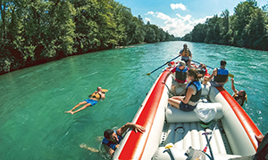 Schlauchboot mit Menschen im und auf dem Wasser