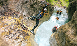 ein Mann springt beim Canyoning ins Wasser